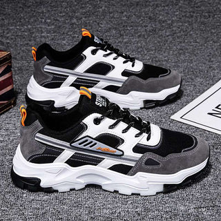 Black, white, and orange casual sneakers with a sporty, chunky design. The sneakers have a mesh upper, lace-up closure, and a thick, textured sole for a comfortable and durable look. The contrasting colors and bold styling make these sneakers an eye-catching athletic footwear option.