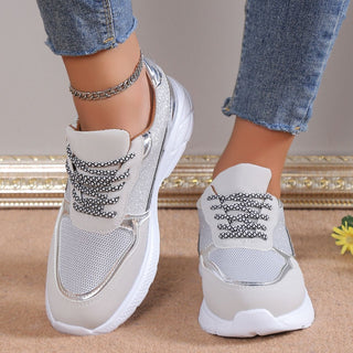 Stylish women's breathable mesh and leather sneakers with lace-up design, showcased on a model's feet against a neutral background.