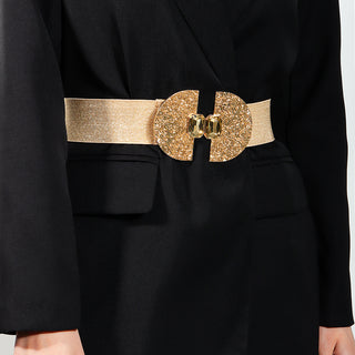 Glamorous gold sequinned belt with decorative clasp on woman's black dress