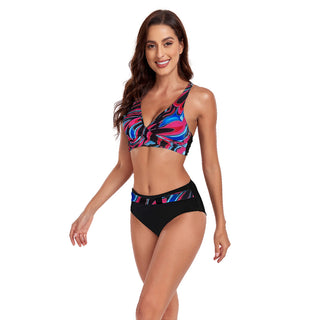 Colorful geometric pattern swimsuit with halter top and contrasting black bottoms, showcasing a young woman's stylish beachwear.