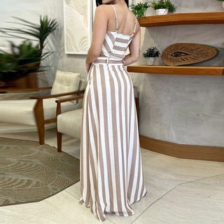 Striped print maxi dress displayed on a female figure in an indoor setting with wooden furniture and decor.