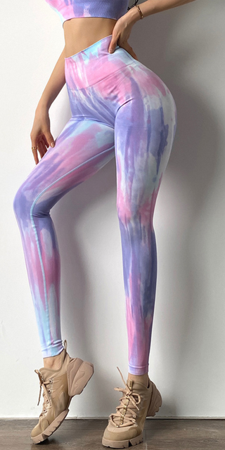 Vibrant tie-dye leggings with athletic fit, slim silhouette, and ankle length design. Pastel pink, purple, and blue tones create a stylish, eye-catching pattern. Complemented by beige lace-up sneakers for a trendy, sporty look.