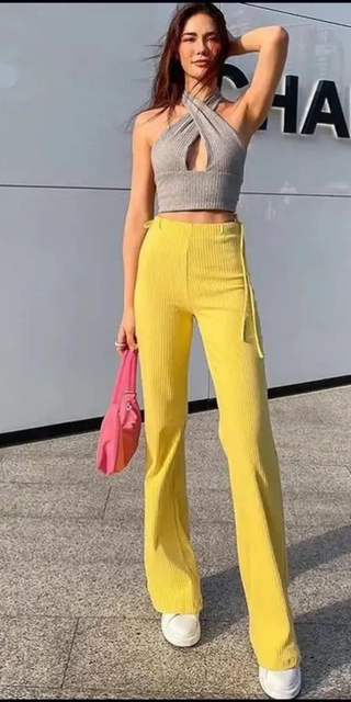 Sleek and stylish yellow high-waisted pants paired with a trendy grey halter-style top for a chic, modern look.