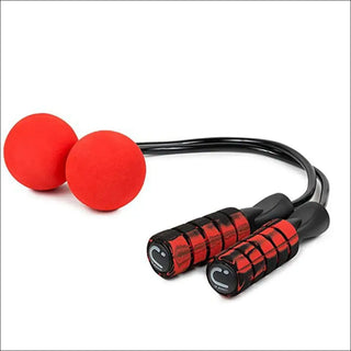 Adjustable red workout resistance bands and weighted balls for strength training and exercise on a plain white background.