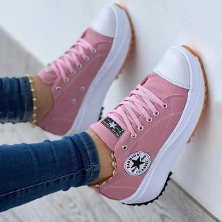 Stylish pink low-top canvas sneakers with thick soles and Converse branding, perfect for a trendy casual look.