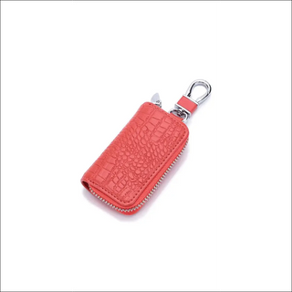 Compact red leather key holder with zipper compartment and metal clasp, compact accessory for organized car keys and wallet storage.