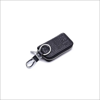 Compact leather key holder with zipper closure, featuring a stylish croc-embossed pattern. Ideal for organizing and protecting your car keys while on the go.