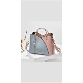 Fashionable patchwork tote bag with block handle and stitching details, in a stylish combination of blue and pink colors, perfect for carrying essentials.