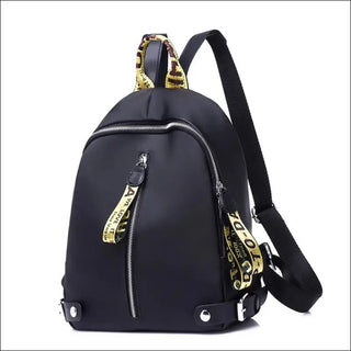 Stylish black backpack with leopard print straps and zippers, featuring a sleek and modern design for fashionable urban wear.