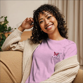 Relaxed and stylish women's t-shirt from K-AROLE brand, featuring a butterfly logo design on a pink background and paired with a cozy knit sweater.