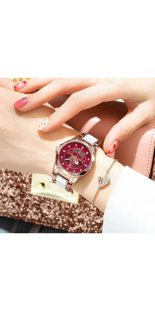 Elegant women's rose gold and red watch with a stylish leather strap, showcased on a hand with neatly manicured nails against a glittering background.