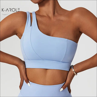 Light blue one-shoulder ribbed yoga bra with shockproof design, part of K-AROLE's activewear collection.